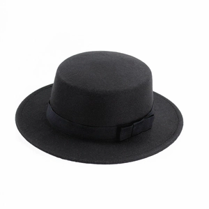 Detail of black wool boater hat featuring a flat top and grosgrain ribbon with bow decoration