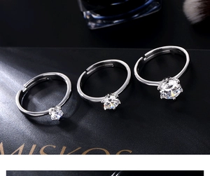 Three silver six-prong cubic zirconia rings with adjustable bands on black gift box