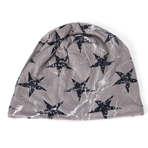 Detail of grey knitted beanie featuring black star patterns with white crackle textures