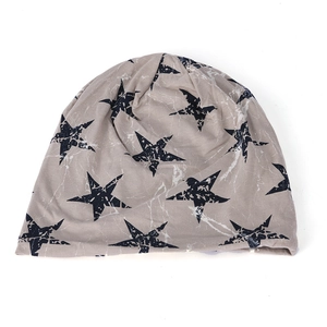 Close-up of light gray beanie featuring blue star prints and soft knit texture detail