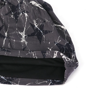 Detailed close-up of beanie fabric with star prints, splattered texture and soft lining