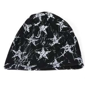 Detailed flat lay of a black knit beanie featuring distressed white star prints