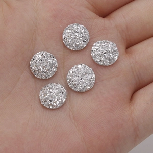Close-up of five 10mm silver resin druzy crystal cabochons held in hand for DIY jewelry