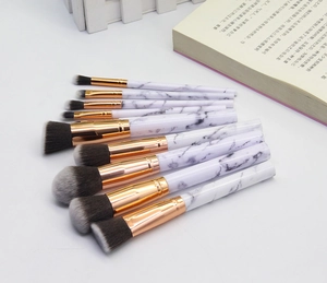 Close-up of 10-piece marble texture makeup brushes with rose gold ferrules on white background