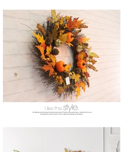 Détail d'une couronne d'automne avec feuilles d'érable, mini citrouilles et baies
