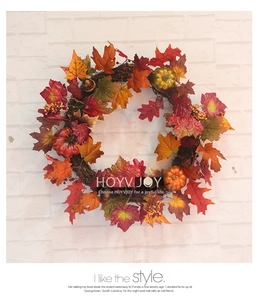 Detailed close-up of autumn harvest wreath with maple leaves, pumpkins, and berries