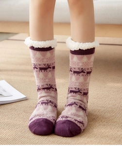 Close-up of thick sherpa lining and festive reindeer pattern on pink thermal floor socks