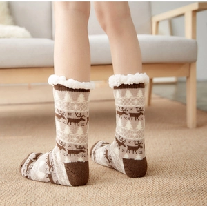 Detail of warm lamb wool lined knitted socks with Nordic reindeer pattern for winter home