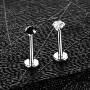 Macro shot of silver stainless steel labret studs with black and clear heart zircons