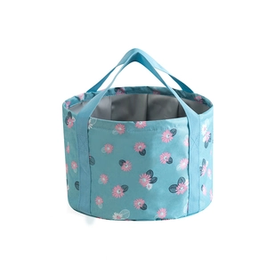 Detail of portable light blue folding bucket with pink daisy pattern and grey lining