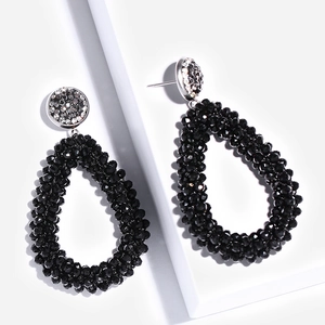 Detail van bohemien zwarte kralen oorbellen met glinsterende strass-steentjes