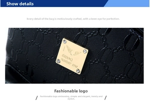 Detailed view of black embossed leather with a gold rhinestone logo plate on bag