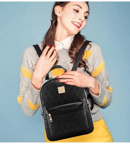 Fashionable black PU leather backpack with chain embossing and golden logo on blue background