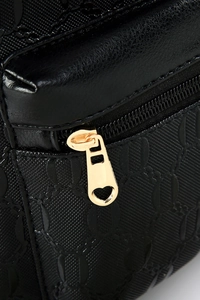 Detailed close-up of embossed pattern on black bag with golden heart-shaped zipper