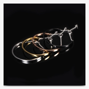 Detail of four U-shaped stainless steel bracelets in gold, silver, rose gold, and black finish