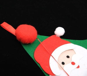 Close-up of a felt Santa Claus Christmas ornament with a white pompom and red ribbon