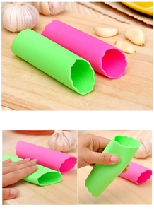Vue macro des éplucheurs d'ail en silicone vert et rose utilisés sur un billot