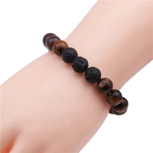 Close-up of 10mm tiger eye and volcanic stone beaded bracelet worn on a wrist