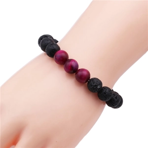 Detailed view of 10mm lava stone and magenta tiger eye bead bracelet on wrist