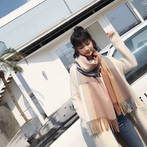 Detail of soft cashmere-feel knit scarf with large earth-tone checks and long fringe