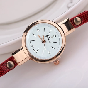 Detailed close-up of rose gold watch dial with rhinestones and red snake pattern strap