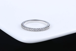 Macro view of a silver ring band featuring a neat row of sparkling clear round zircons