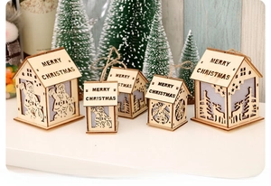 Detail of five wooden LED Christmas houses with laser-cut reindeer and Santa patterns