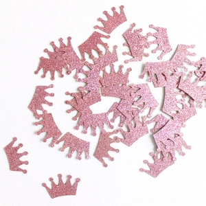 Close-up of pink glitter crown table confetti for graduation party decorations