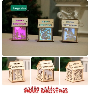 Detail of wooden Christmas house LED lanterns with festive reindeer and Santa carvings