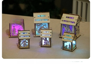 Close-up of lighted wooden Christmas house ornaments with Merry Christmas engravings
