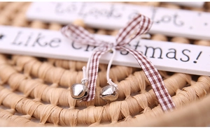 Detail of wooden Christmas tree ornament with plaid bow and small silver bells