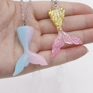 Macro shot of colorful gradient mermaid tail pendants with shimmering resin and scale details