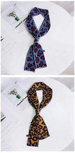 Detail of double-sided leopard print skinny silk scarf in blue and brown pattern