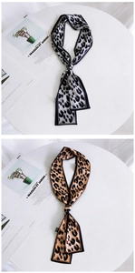 Detail of leopard print skinny scarves in grey and brown with elegant knotted styling
