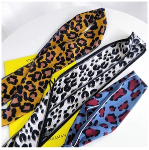 Detailed view of leopard print silk scarves in yellow, white, and blue patterns