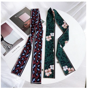 Close-up of double-sided leopard print twilly scarves with premium silk satin finish