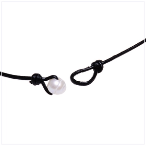 Macro detail of natural freshwater pearl clasp on black leather cord necklace