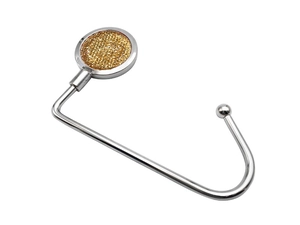 Close-up of portable metal bag hook with glittering gold rhinestones on top surface