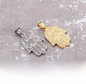 Macro shot of silver and gold Hamsa hand pendants with intricate hollow filigree patterns