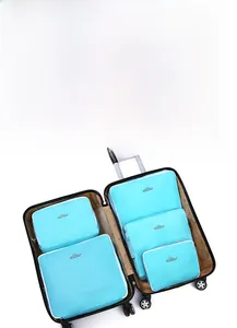Detail view of five sky blue mesh travel organizers neatly packed inside a black suitcase