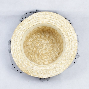 Detailed interior of straw hat showing beige sweatband and black polka dot lace veil