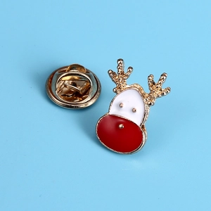 Detail of reindeer brooch with gold alloy base and red enamel nose on blue background
