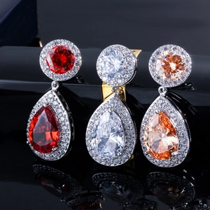 Dettaglio di orecchini a goccia con zirconi in rosso, bianco e color champagne