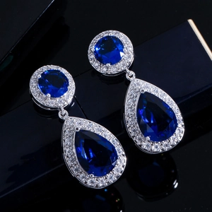 Vista macro di orecchini pendenti in argento con zaffiri blu e micro zirconi incastonati