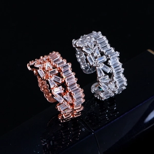 Macro shot of rose gold and silver baguette-cut zircon rings on a sleek black background