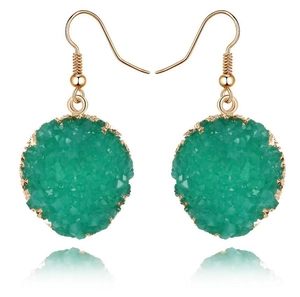 Elegantes pendientes de piedra verde sintética con borde dorado sobre fondo blanco