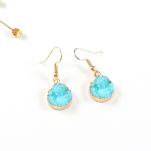Detalle de pendientes de piedra druzy azul con baño de oro y diseño de gancho fino