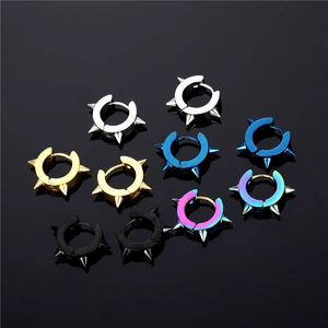 Five pairs of punk spiked hoop earrings in assorted metallic finishes on black surface