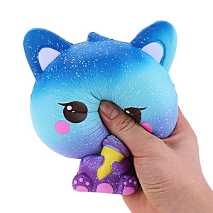 Close-up of hand squeezing blue galaxy cat ice cream squishy showing slow rebound effect