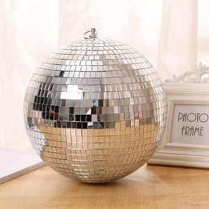Reflective glass disco mirror ball with hanging loop on a wooden surface backdrop